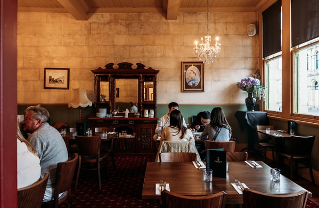 Table of four enjoying dinner in a quaint Victorian style pub room at The Criterion Hotel in Ōamaru
