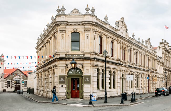 Exterior of The Criterion Hotel in Ōamaru with a person walking past the front in a checkered jacket