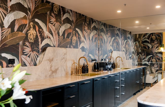 Tropical wallpaper on the wall and a long sink area at The Eve Apartment.