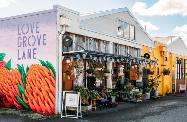Building exterior of The Flower Crate with a Lovegrove Lane mural on the side of the building.