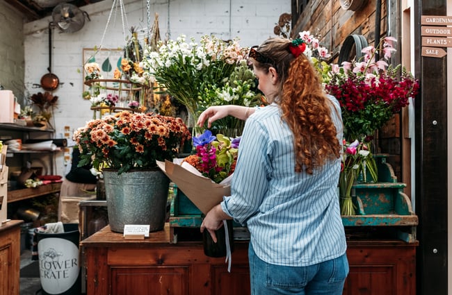 Shop assistant tending to a bouquet of flowers at The Flower Crate.