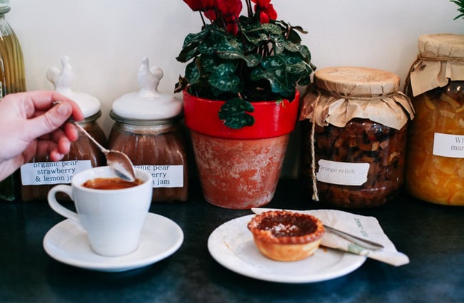 Close up of a coffee and tart.
