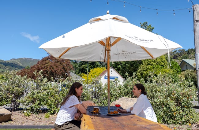 Two women sitting at outdoor table at The Grand Hotel in Akaroa