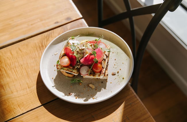 A close up of loaded toast on a table in the sunshine at the Greedy Cow in Tekapo.