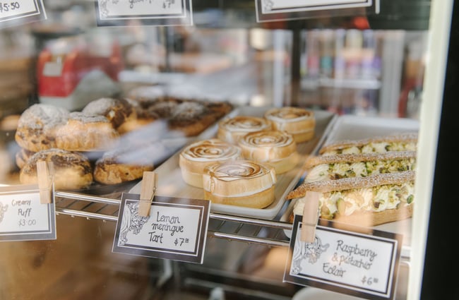 Close up of cakes and meringues behind a glass cabinet at the Greedy Cow Café in Tekapo.