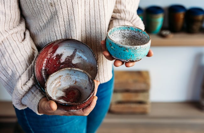 Customer holding three ceramic items in a shop at The Green.