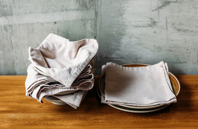 A close up of fabric napkins on plates.