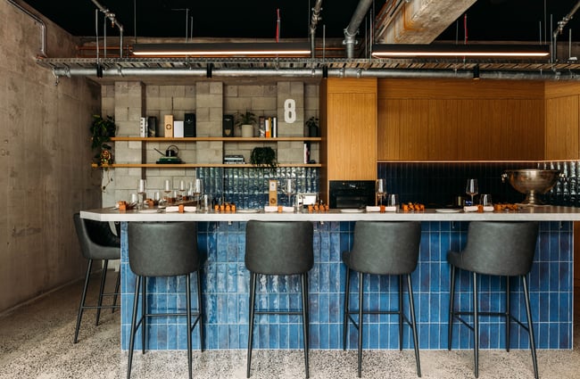 High seats placed around a kitchen and bar area.