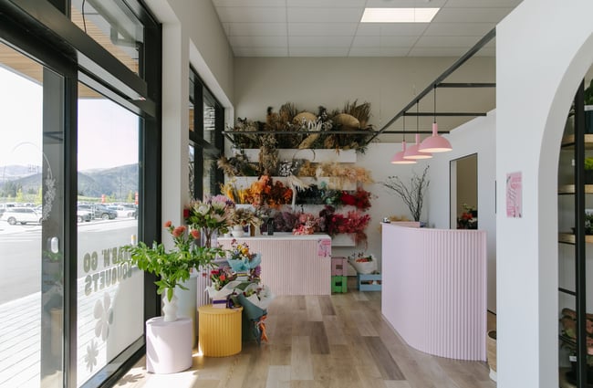 The interior of The Green Room flower and plant store with light pink counters.