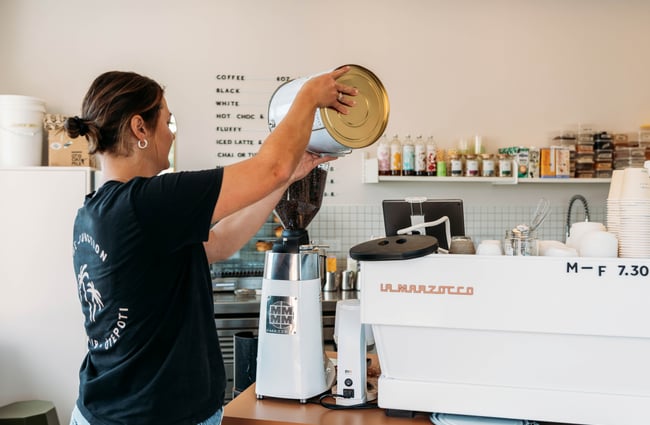 Barista filling up the beans at The Junction.