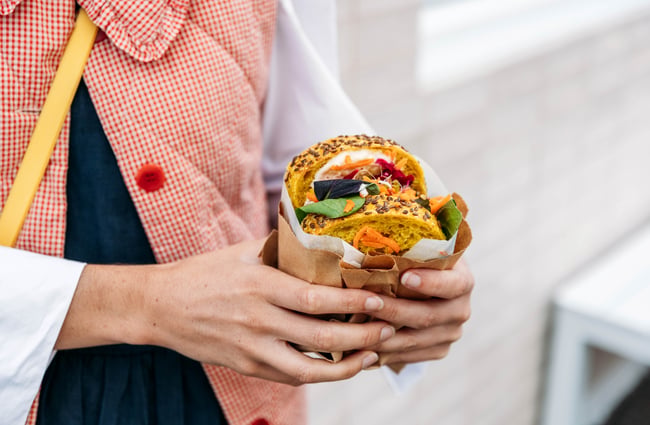 Customer holding their sandwich outside The Junction.