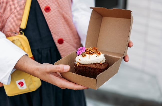 Customer holding a slice of cake outside The Junction.