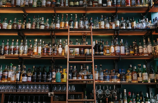 Close up of liquor bottles on a shelf.