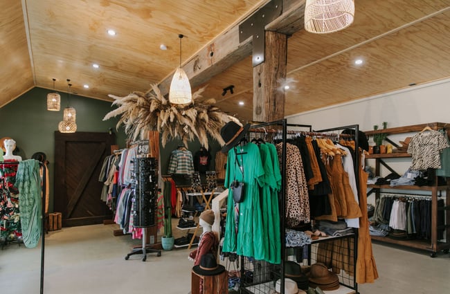 Clothing on display on racks inside The Little Red Fox store in Fairlie.