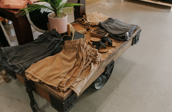 A close up of shorts and sandals on a low table at The Red Little Fox store in Fairlie.