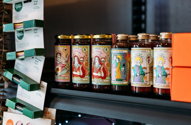 A close up of hot sauce on a shelf.