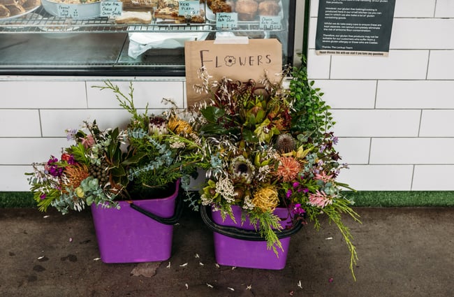Fresh flowers in purple buckets.