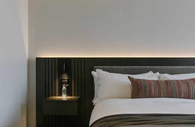 A close up of a bedside table inside a hotel room.