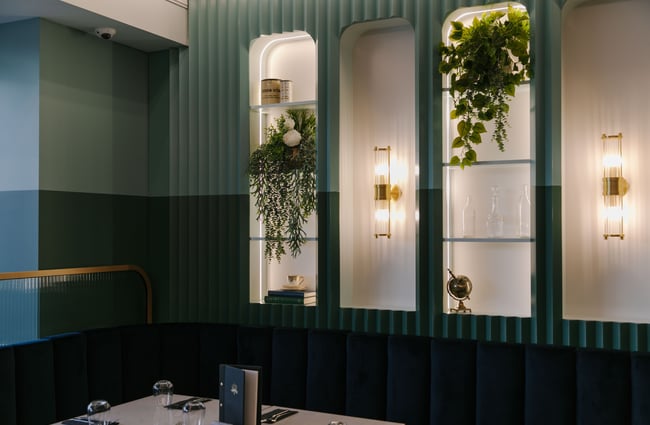 A corner of the hotel restaurant decorated in dark greens.