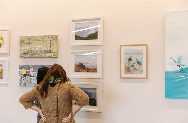 Two women looking at artwork at the exhibition space at The Mayfair.