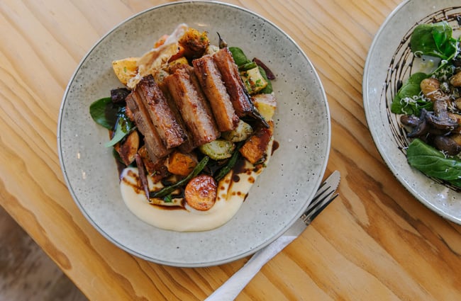 Pork belly with mashed potato dish on a table at The Moutere Inn, Nelson Tasman.