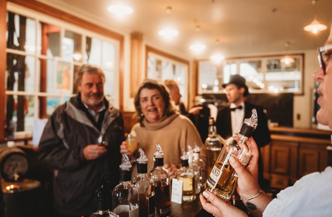 Bartender showing a whisky to customers at The NZ Whisky Cellar Door.