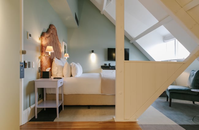 Bed facing out towards a big angled skylight.