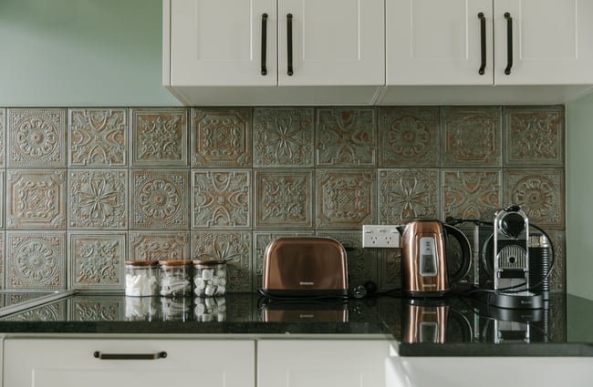A close up of a toaster and kettle on a kitchen bench.