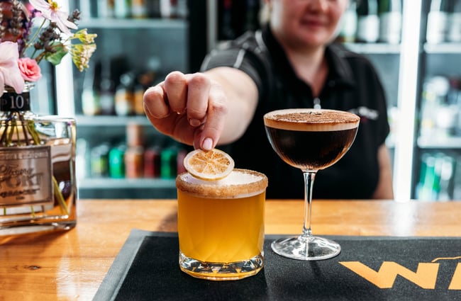 Bartender garnishing cocktails at The Post Office Cafe and Bar.