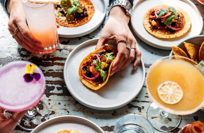 Tacos and other Mexican dishes and cocktails on the table at Paloma.