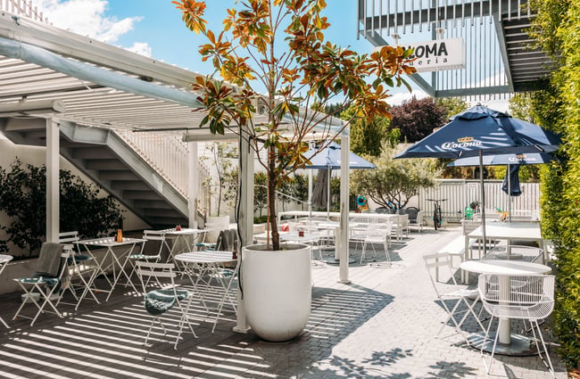 Outdoor tables and chairs with umbrellas in The Precinct.