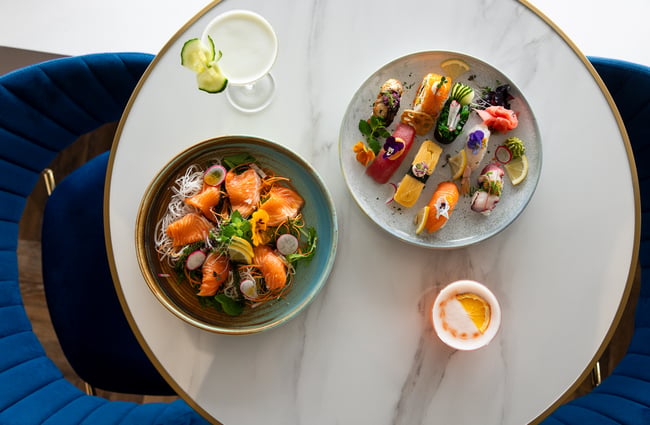 A birdseye view of two plates of food on a white table.