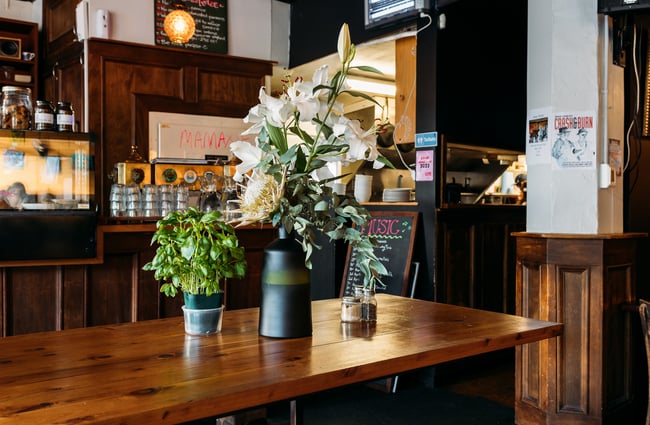 White flowers on display on a large wooden table.