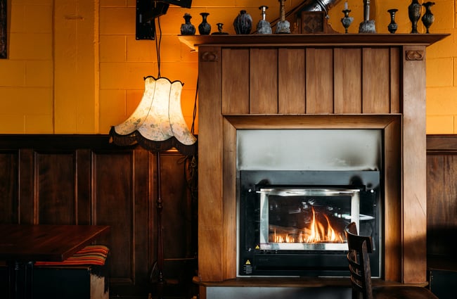 A lampshade leaning up against a fireplace.