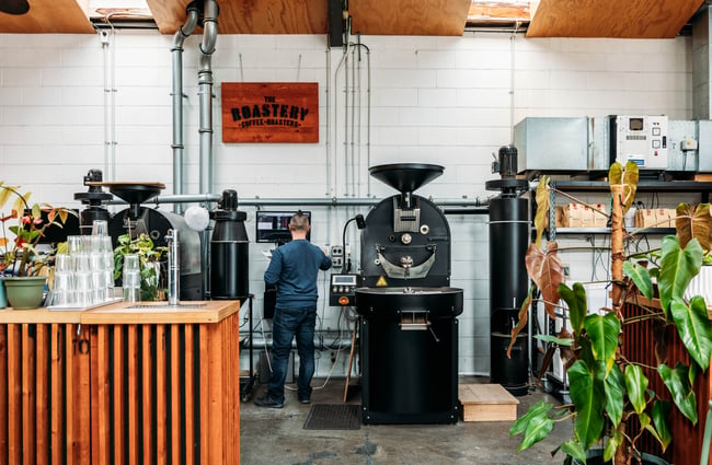 Man standing at the machine roasting coffee beans in The Roastery.