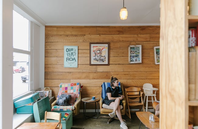 A woman sitting crossed legged on a couch at The Running Duck cafe in Geraldine.