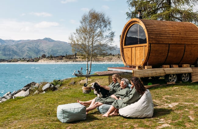 Three people on bean bags looking out towards a lake.