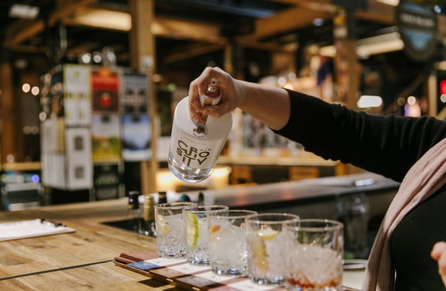 Close up of person pouring Curiosity Gin into glasses.