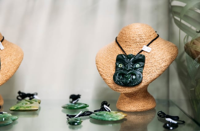 Green stone necklaces on display inside a cabinet.