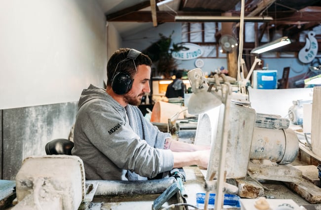 A man working at a machine wearing head phones.