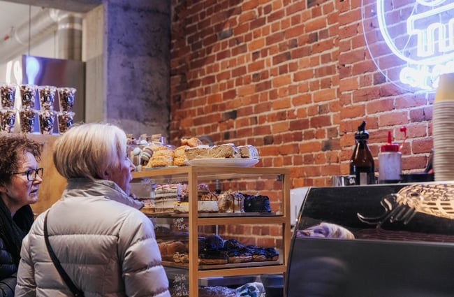 Two women thinking about what to order at the counter.