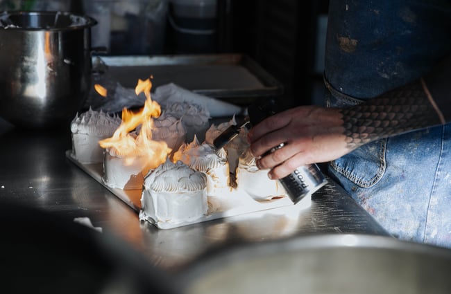 Meringue-topped tarts getting torched.