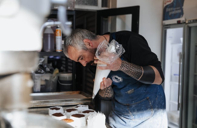 Icing being piped onto cupcakes.