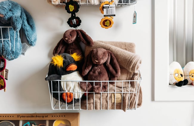 Soft toys for kids in wire basket at boutique store