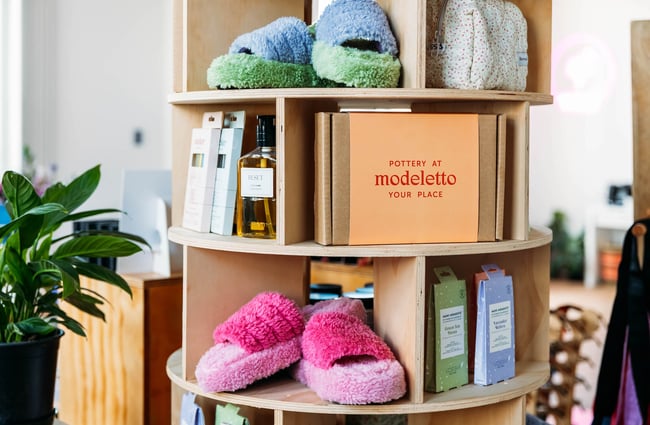 Fluffy slippers and pottery kit on shelf at boutique store