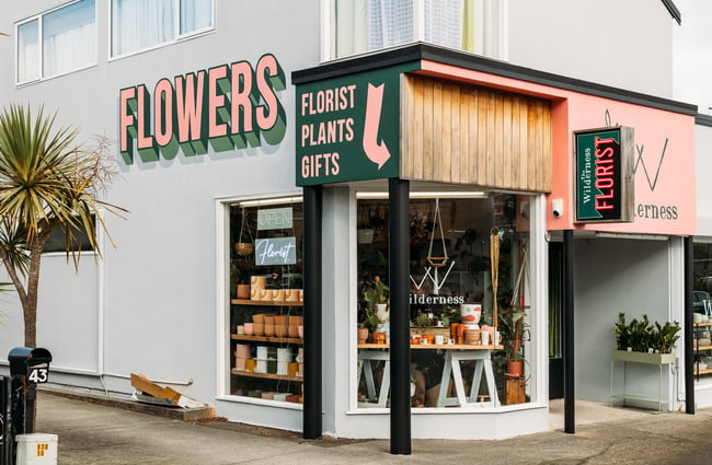 The Wilderness shop on the corner of a grey building.