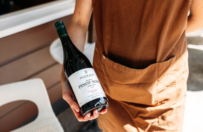 A person holding a bottle of wine.