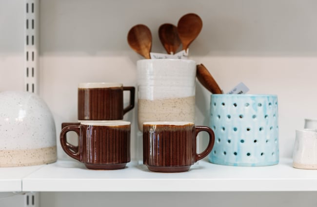 Close up on a utensil pot and some coffee cups on display at The Wobbly Pot.