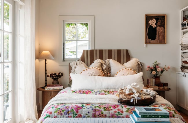 Bed made-up with plush throws and cushions.