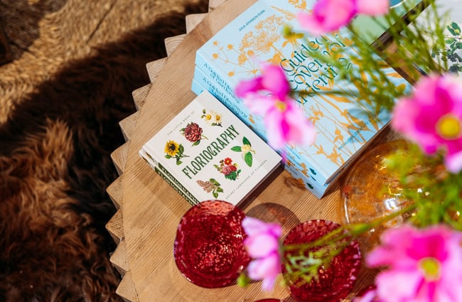 A close up of books on flowers on display on a table.